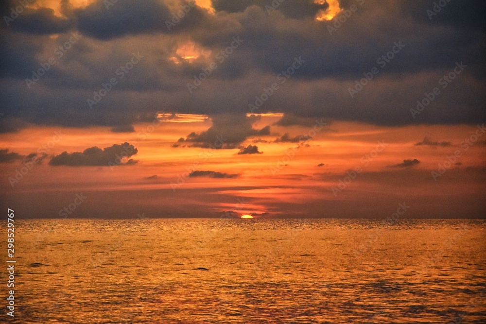 Phuket beach sunset, colorful cloudy twilight sky reflecting on the sand gazing at the Indian Ocean, Thailand, Asia. Phuket beach sunset, colorful cloudy twilight sky reflecting on the sand gazing at the Indian Ocean, Thailand, Asia.