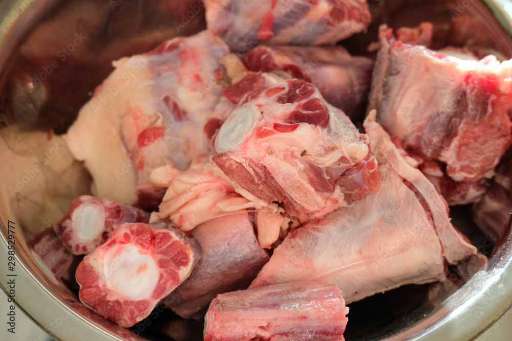 Cutted oxtail in a bowl. Raw meat