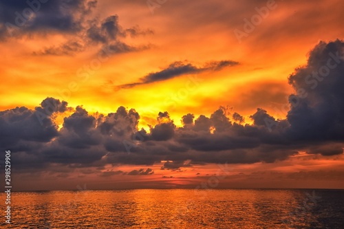 Phuket beach sunset, colorful cloudy twilight sky reflecting on the sand gazing at the Indian Ocean, Thailand, Asia.