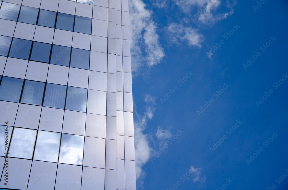 Obraz premium Architectural background, fragment of a modern office building against blue sky