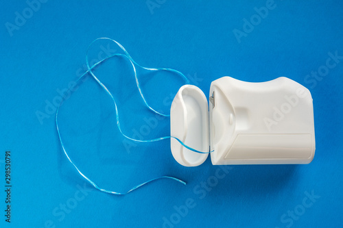 dental floss on a blue background, the concept of care for the oral cavity, preventing tooth decay, copyspace