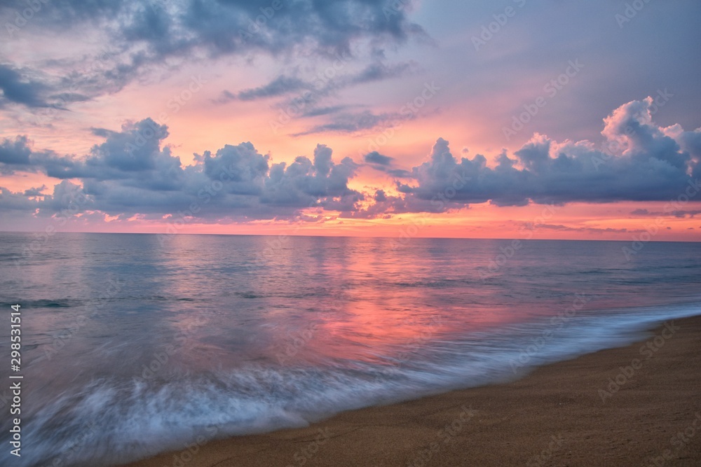 Phuket beach sunset, colorful cloudy twilight sky reflecting on the sand gazing at the Indian Ocean, Thailand, Asia. Phuket beach sunset, colorful cloudy twilight sky reflecting on the sand gazing at the Indian Ocean, Thailand, Asia.