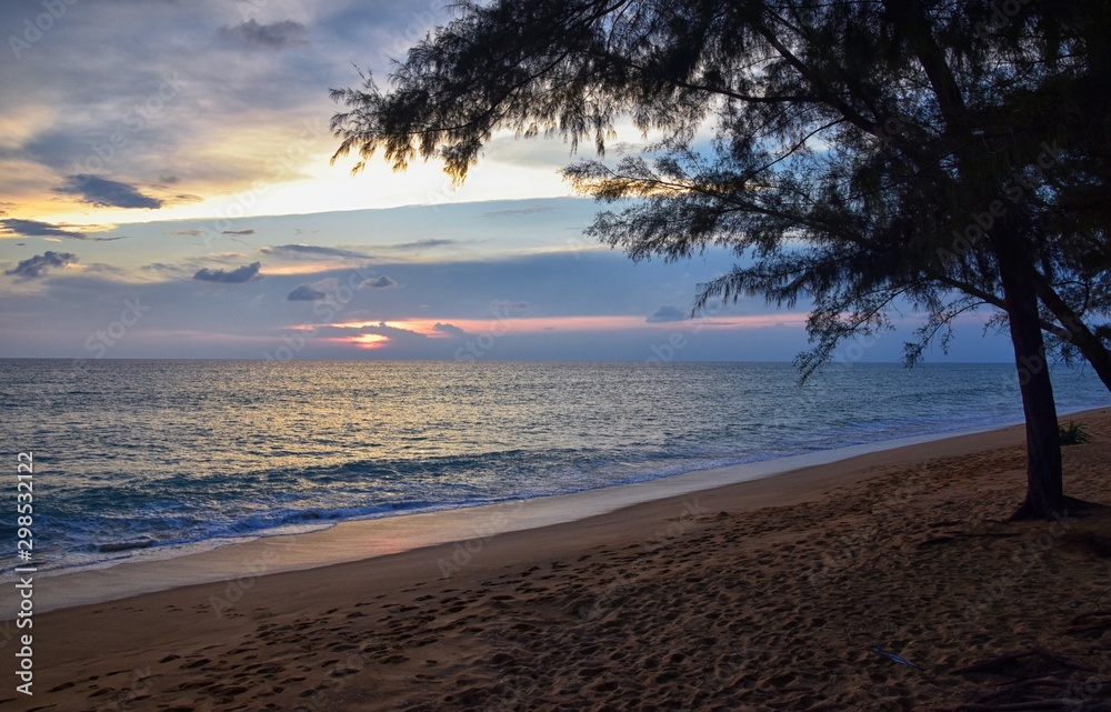 Phuket beach sunset, colorful cloudy twilight sky reflecting on the sand gazing at the Indian Ocean, Thailand, Asia. Phuket beach sunset, colorful cloudy twilight sky reflecting on the sand gazing at the Indian Ocean, Thailand, Asia.