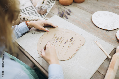 The potter's hands are shaped a cup from a clay. The process of creating pottery. The master ceramist works in his studio. Close-up, only hands. Crockery from clay own hands. photo