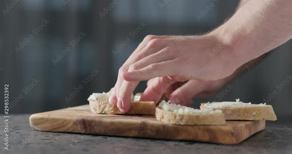 Slow motion man hand spreading cream cheese on slice of ciabatta Slow motion man hand spreading cream cheese on slice of ciabatta