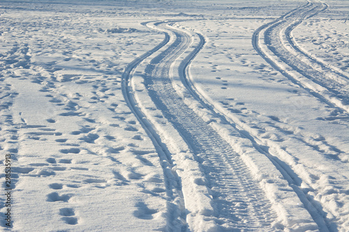 traces of a snowmobile and human footprints in the snow  trails in the snow