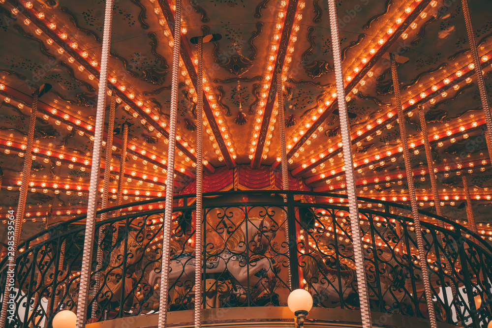 Obraz premium Old carousel with horses in a holiday autumn evening park with nobody