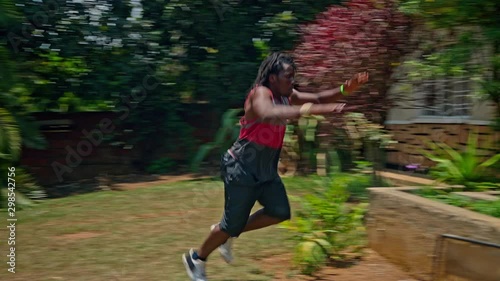 Wide view shot young african man practicing parkour at home makes flips and jimping photo