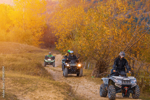 All terrain vehicles, quad bikes, atv, riding through beautiful rural scenery in autumn