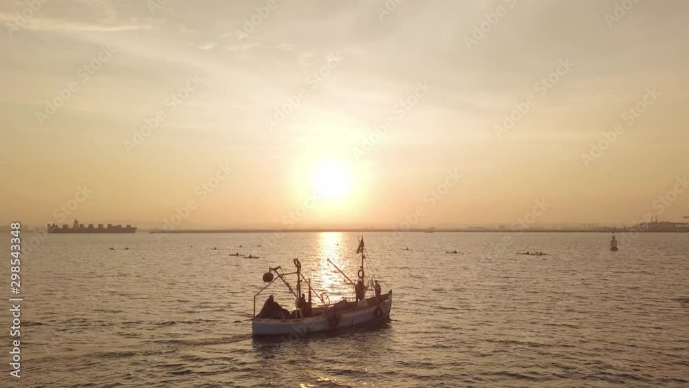 Fishing boat on the background of golden sunrise. 