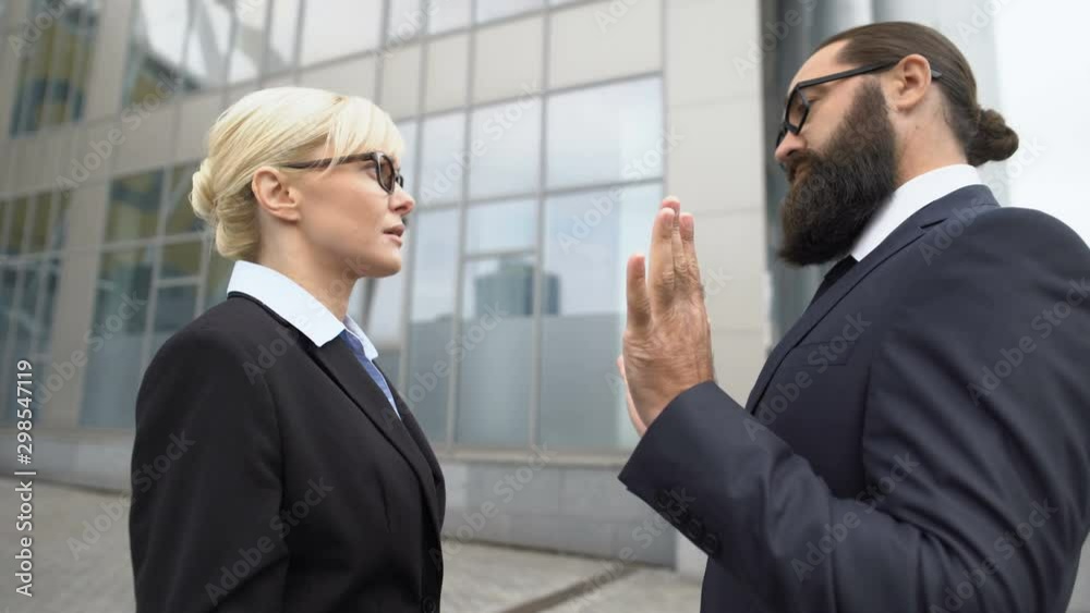 Man touching female by shoulder at business meeting, woman pushing harasser Man touching female by shoulder at business meeting, woman pushing harasser