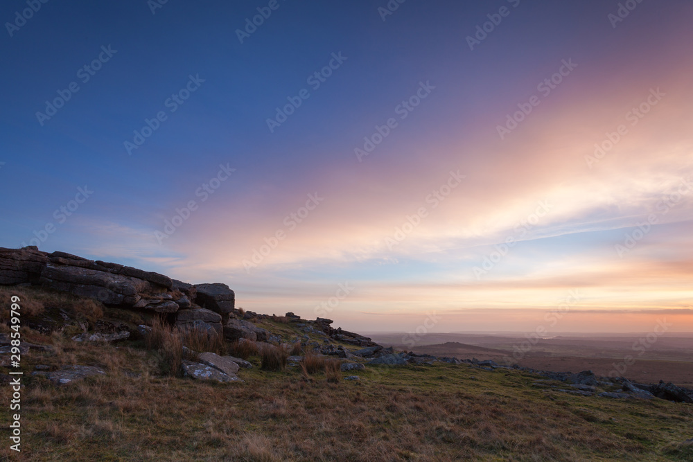 Sunset sky over granite rocks at Little Staple Tor on Dartmoor National Park