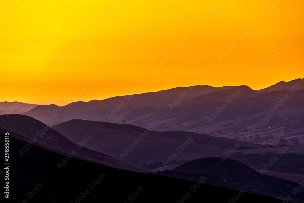 Yellow Sunrise over Silhouetted Mountains