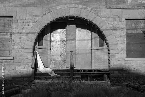 The archway of an old vacant building with a single sheet left behind