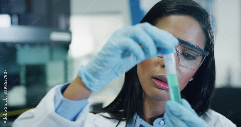 Portrait of dark skin female scientist is analyzing a liquid to extract the DNA and molecules in the test tubes in laboratory. Portrait of dark skin female scientist is analyzing a liquid to extract the DNA and molecules in the test tubes in laboratory.