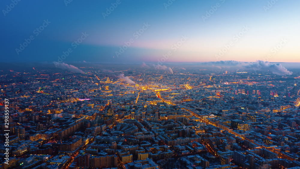 Beautiful aerial view to Moscow city on the sunset. Picturesque motion of the evening metropolis with street and building lights gradually turning on and colorful sky on the background.