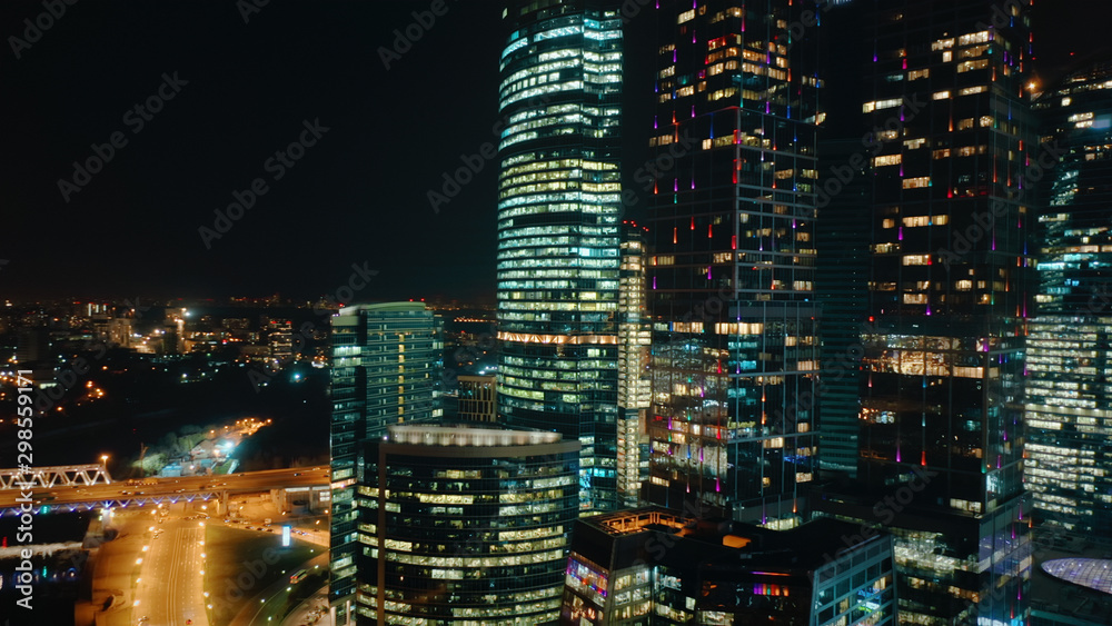 Amazing close up view from above to Moscow City Center on the night. Camera slowly moves away showing amazing cityscape with bright glittering lights of buildings, streets and traffic.