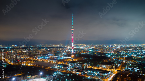 Motion of Ostankino tower on the night, view from above. Picturesque aerial panorama of Moscow center with bright glittering buildings, streets and traffic. © railwayfx