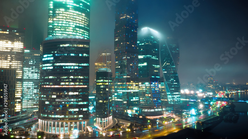 Amazingly beautiful of Moscow City Business Center on the foggy night with glittering lights from buildings, streets and traffic. Close up aerial shot.