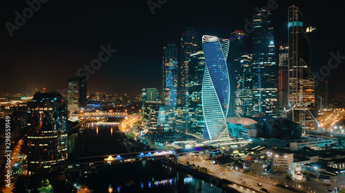 Beautiful view from above to Moscow City Center on the night with bright glittering lights of buildings  streets and traffic. Camera slowly moves towards skyscrapers showing amazing cityscape.