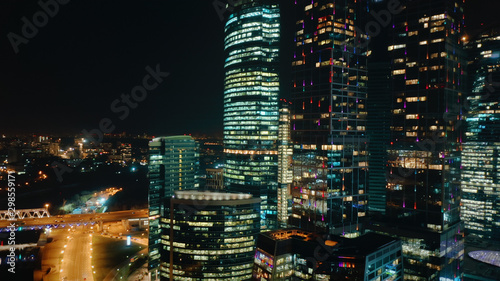 Amazing close up view from above to Moscow City Center on the night. Camera slowly moves away showing amazing cityscape with bright glittering lights of buildings, streets and traffic.