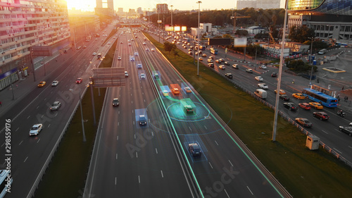 Beautiful aerial view to autonomous cars self-driving on the highway in Moscow. Picturesque aerial panorama of the road traffic in a big city on the sunset.