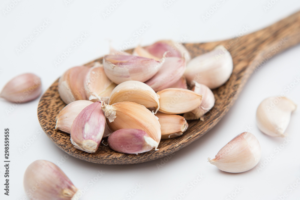 Garlic cloves on a wooden ladle  on white background