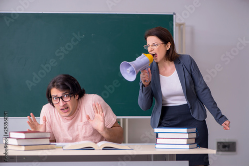 Konstfotografi Old female teacher and male student in the classroom