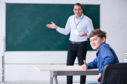 Young male teacher and boy in the classroom
