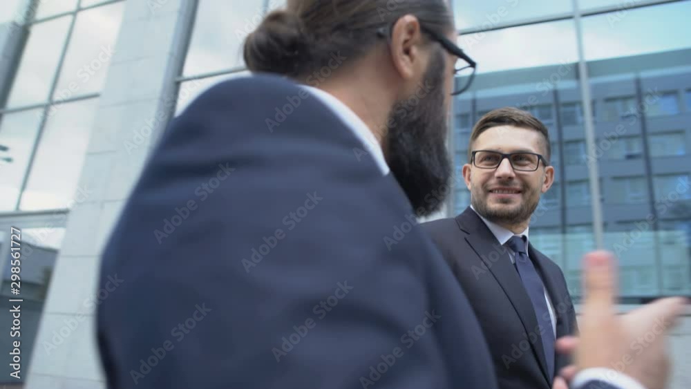 Two business men walking street and actively discussing contract conditions Two business men walking street and actively discussing contract conditions