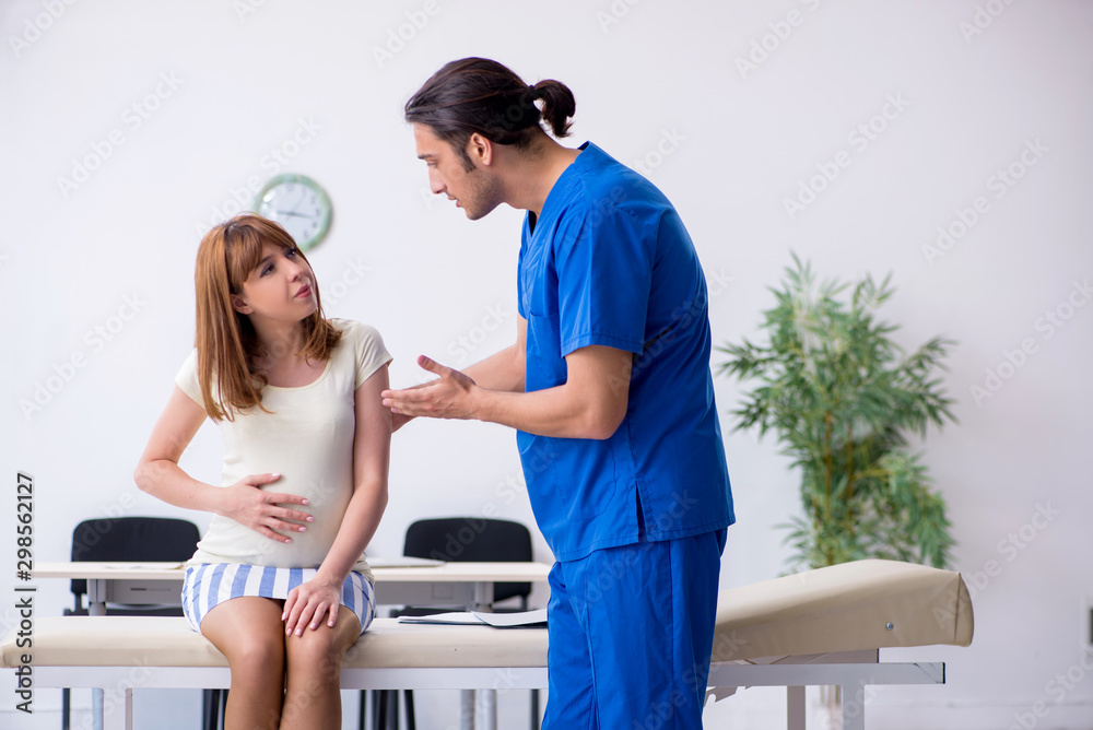 Fototapeta premium Pregnant woman visiting male doctor gynecologist