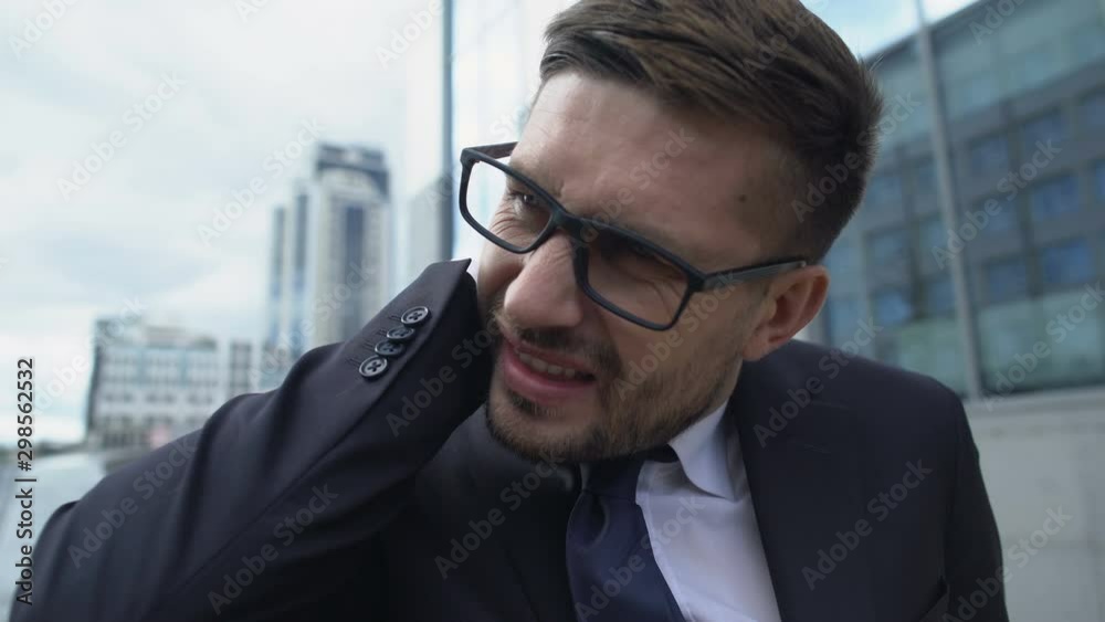 Man in suit suffering sharp neck pain outdoor, spinal diseases symptom, cramp Man in suit suffering sharp neck pain outdoor, spinal diseases symptom, cramp