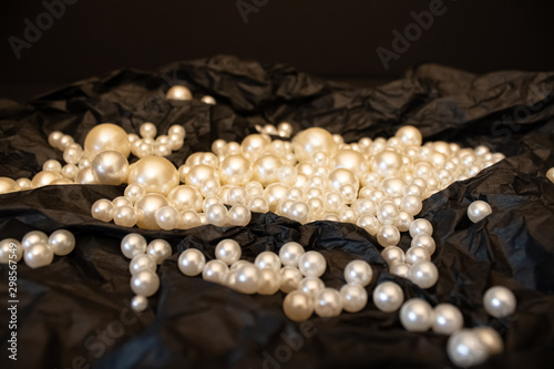 White pearls on the black stylish background.