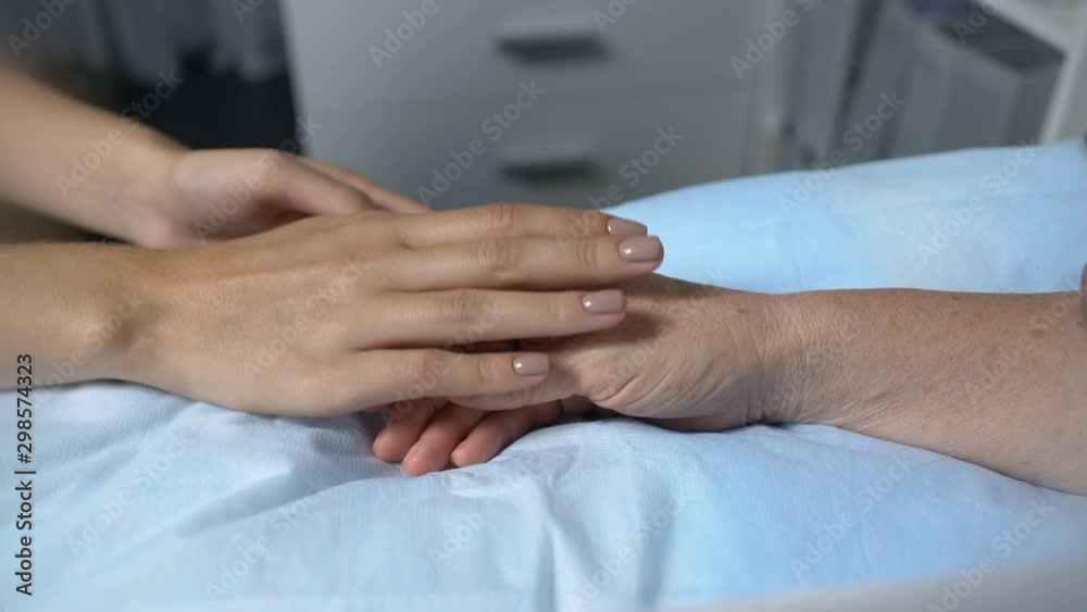 Daughter or granddaughter leaving ill mother to rest in hospital ward, support