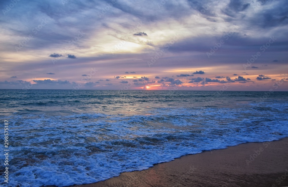 Phuket beach sunset, colorful cloudy twilight sky reflecting on the sand gazing at the Indian Ocean, Thailand, Asia. Phuket beach sunset, colorful cloudy twilight sky reflecting on the sand gazing at the Indian Ocean, Thailand, Asia.