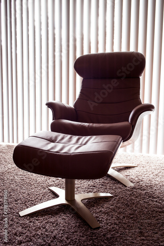 Obraz na płótnie Classic, modern chair with ottoman in a low lit room