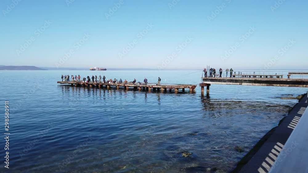 fishermen with fishing rods catch fish from the sea pier.Russia, Vladivostok., 27 October 2019. fishermen with fishing rods catch fish from the sea pier.Russia, Vladivostok., 27 October 2019.