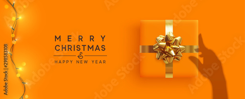 Merry Christmas and Happy New Year. Background with realistic gift box, bright christmas lights garland. Silhouette shadow from the hands holds Xmas presents. Creative getting card, holiday banner.
