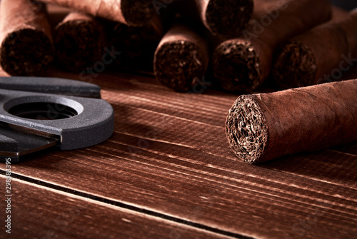 Still life with cuban cigars and cutter on old wooden board table photo