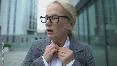 Mature company head suffering dyspnea and fever, menopause symptoms, health