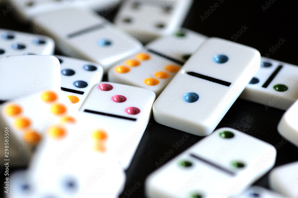 White domino scattered on a black background close-up White domino scattered on a black background close-up
