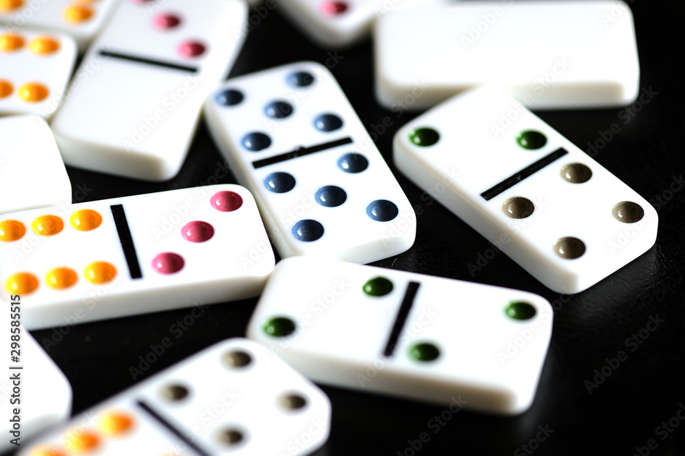 White domino scattered on a black background close-up White domino scattered on a black background close-up