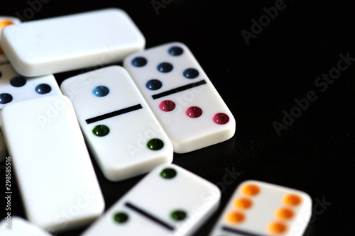 White domino scattered on a black background close-up