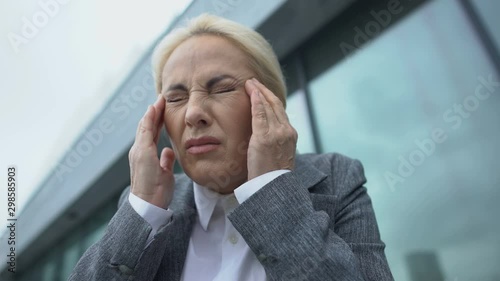 Female company head in eyeglasses feeling strong teeth pain, dental problems