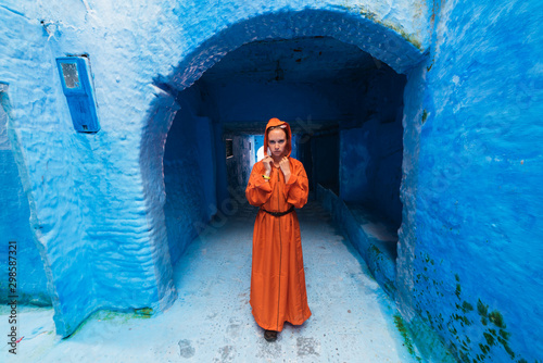 girl in Moroccan clothes in a blue city © nelen.ru