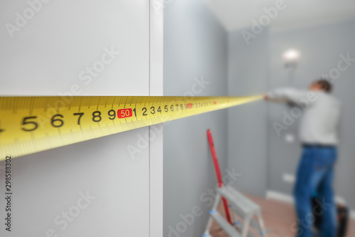 Man with tape-line measuring distance