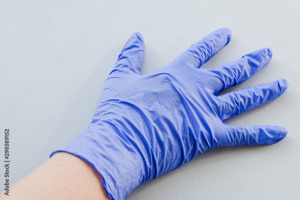 Human hand in blue latex glove, personal protective equipment medical accessory to ensure the safety of staff and patient. To protect the skin in contact with toxic substances. Human hand in blue latex glove, personal protective equipment medical accessory to ensure the safety of staff and patient. To protect the skin in contact with toxic substances.