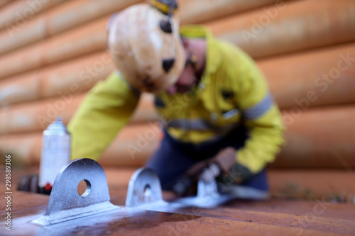 Crane lifting lug with white paint with defocused NDT technician conducting MPI inspection at the background mining construction site Perth, Australia   