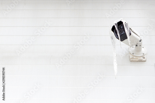 Video camera on the wall. Icicles on the camera block the lens.