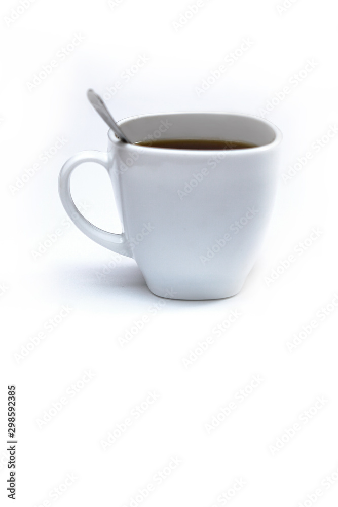 White cup of coffee with a spoon on an isolated background. Black cappuccino drink in a bowl White cup of coffee with a spoon on an isolated background. Black cappuccino drink in a bowl